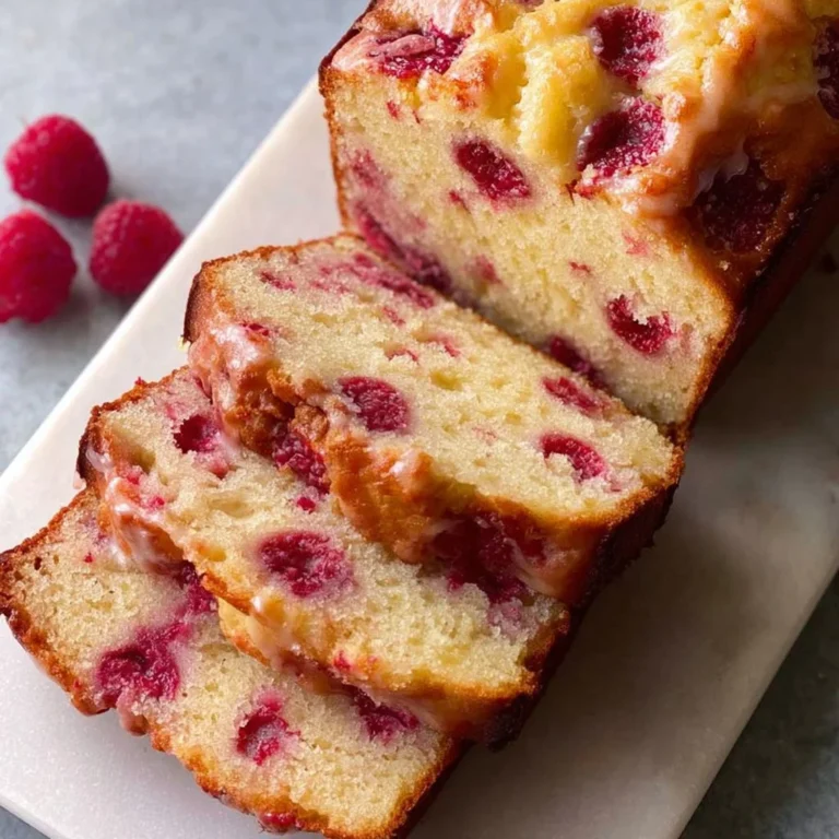 Gluten-free raspberry lemon loaf garnished with fresh raspberries and lemon zest